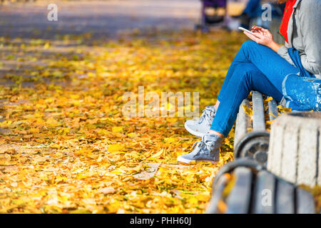 Junge Frau sitzt auf einer Bank im park Stockfoto