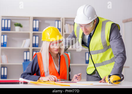 Bauarbeiter in Diskussion im Büro vor dem Anlassen Stockfoto