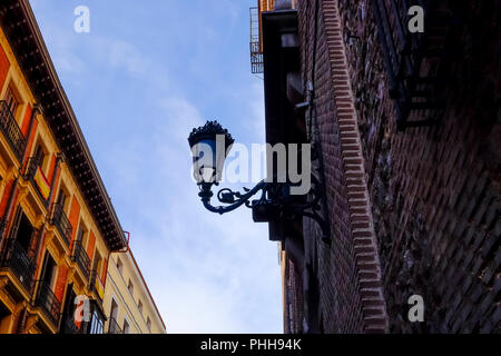 Silhouette eines Lamp Post mit einem kleinen Spatz sitzt auf ihn gegen ein blauer Himmel und einige Wolkenfelder in Madrid. Stockfoto