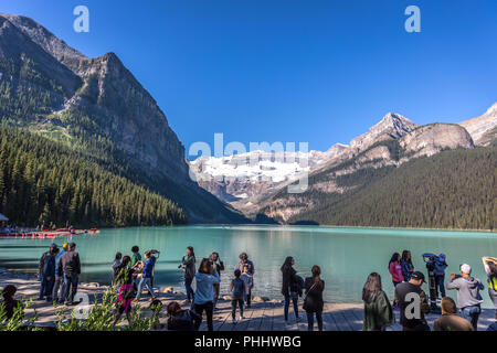 Banff, Kanada - Vor 14 2017 - Gruppe der Touristen vor Lake Moraine in den frühen Morgen. Blauer Himmel, Berge im Hintergrund, Schattierungen von Baum Stockfoto