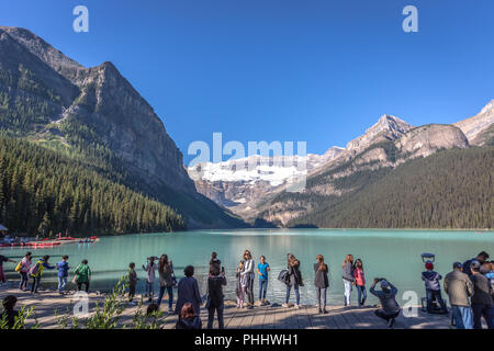 Banff, Kanada - Vor 14 2017 - Gruppe der Touristen vor Lake Moraine in den frühen Morgen. Blauer Himmel, Berge im Hintergrund, Schattierungen von Baum Stockfoto