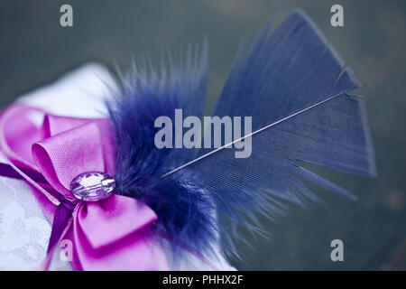Kissen für Trauringe, mit einem blauen Feder Stockfoto
