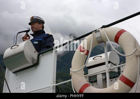 Der Skipper der PS-Lötschberg (1914 durch Escher-Wyss, Zürich gebaut) Piloten das Schiff in das Dock in Iseltwald am Brienzersee, Schweiz Stockfoto