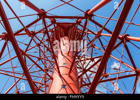 Red Gusseisen Leuchtturm vor blauem Himmel von unten Stockfoto