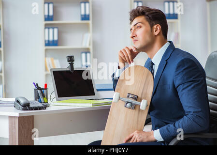 Junge Unternehmer mit Skate im Büro im Sport Konzept Stockfoto