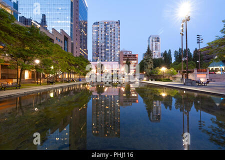 Einen künstlichen Teich in Mel Lastman Square in Richtung Yonge Street in der Dämmerung. North York, Toronto, Ontario, Kanada. Stockfoto