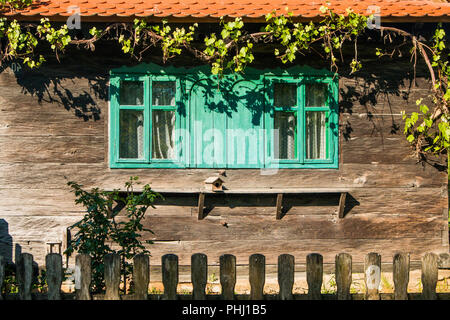 Idyllischen alten traditionellen Holzhaus mit Vogel Home, Wein- und Zaun im Lonjsko Polje, Kroatien, Detail Stockfoto