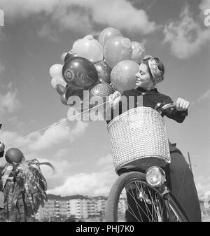 1940 Frau auf einem Fahrrad. Schwedische Schauspielerin Viveca Lindfors auf ihrem Fahrrad holding Luftballons. Schweden August 1940. Foto Kristoffersson 159-31 Stockfoto