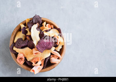 Verschiedenen pflanzlichen Chips auf grauem Hintergrund, kopieren. Verschiedene getrocknete rote Beete, Karotten, Kürbis Gemüse Chips - gesunden veganen Snack. Stockfoto