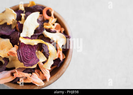 Verschiedenen pflanzlichen Chips auf grauem Hintergrund, kopieren. Verschiedene getrocknete rote Beete, Karotten, Kürbis Gemüse Chips - gesunden veganen Snack. Stockfoto