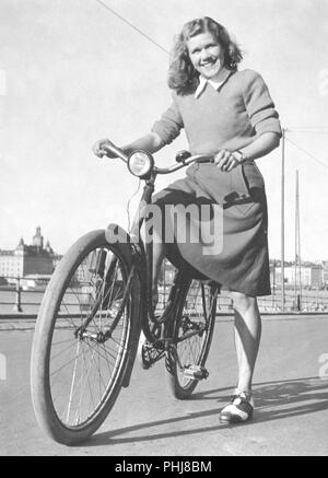 1940 Frau auf einem Fahrrad. Eine lächelnde junge Frau auf einem Fahrrad Frauen an einem sonnigen Tag. Schwedische runner Anna Larsson. 1922-2003. Inhaber von vier Weltrekorde. Schweden 1940 Stockfoto