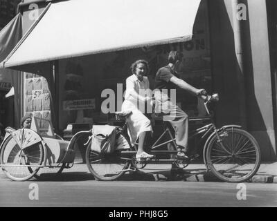 1940 s Paar auf einem Tandem Fahrrad. Das junge Paar haben ihren Sohn in ein Fahrrad Schlitten hinter Ihrem Fahrrad. Schweden 1940 Stockfoto