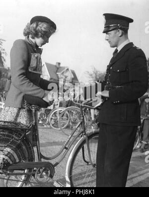 1950er Frau und Polizist. Die junge Frau ist ein Teilnehmer an einer Veranstaltung und ein Polizist ist die Überprüfung, dass die fahrradklingel Ok funktioniert. Es ist an die Griffe montiert und wird als Warnung Fußgänger und andere Radfahrer wenn needen verwendet. Schweden 1950 Stockfoto
