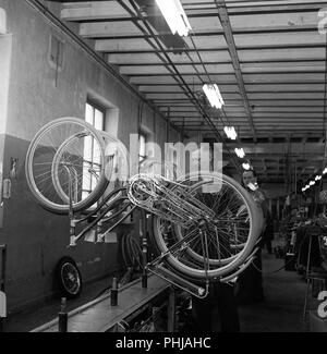 Fahrradfabrik in den 1950er Jahren. Ein Arbeiter am Fahrrad Hersteller Nymans in Uppsala arbeitet an der Produktionslinie mit Frauen Fahrräder. Schweden 1956 ref CV 15-9 Stockfoto