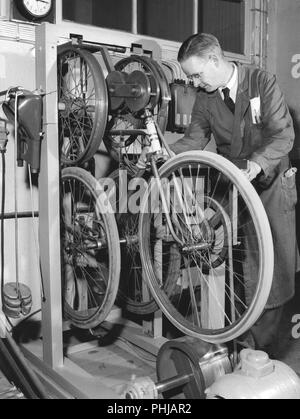 Werk in den 1950er Jahren. Ein Arbeiter an Fahrrad und Motorrad Monark in Schweden. Die Fahrräder geprüft werden und auf dieser Maschine namens der Shaker, das Fahrrad läuft ein 1000 km Testlauf. Schweden 1958 Stockfoto