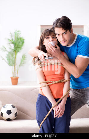 Mann binden bis seine Frau zur sportschau Fußball Stockfoto