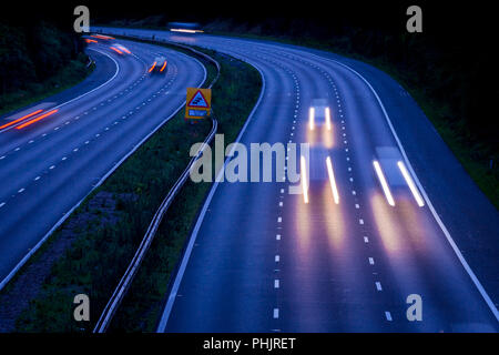 Autobahn M42 bei Dämmerung mit bewegten Fahrzeugen mit Bewegungsunschärfe Stockfoto