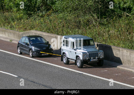 SWB-Land Rover Defender Abschleppen eines anderen Fahrzeugs mit einem Seil, auf dem Pannenstreifen, Freizeit-, Off Road-, Rettungs-, Fahrzeug robuste Abschleppdienst, Großbritannien Stockfoto