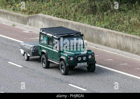 2005 (54) Land Rover Defender 110 County TD5 mit Schnorchelauspuff, Freizeit, Geländeeinsatz, robustes Fahrzeug, mit Anhänger auf der Autobahn M6, Großbritannien Stockfoto