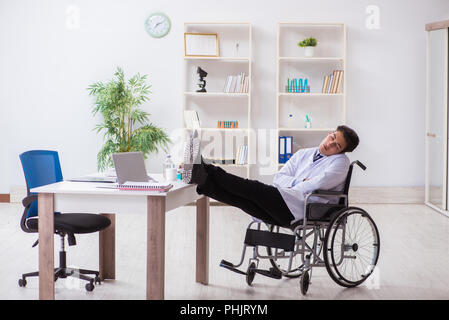 Arzt ruht auf Rollstuhl im Krankenhaus nach der Nachtschicht. Stockfoto