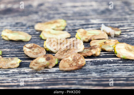 Liegen auf einem Holzbrett mit einem Stapel der trockene, faltige Bohne-sämenkorner close-up, Seitenansicht Stockfoto
