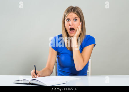 Schöne Studentin ist in Panik, weil sie zu viel zu lernen hat. Stockfoto