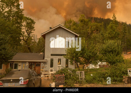 Flammen aus dem Taylor Creek und Klondike Feuer verbrennen ein Berg in Richtung einer Residenz in der Rogue River Siskiyou National Forest August 11, 2018 in der Nähe von Grants Pass, Oregon. Stockfoto