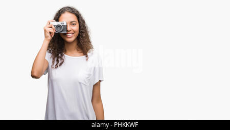 Junge Hispanic Frau Aufnahme von Bildern mit Vintage Kamera mit einem glücklichen Gesicht stehen und lächelnd mit einem selbstbewussten lächeln zähne Stockfoto