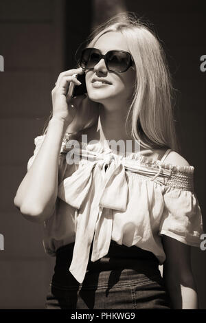 Happy Mode blonde Frau in Sonnenbrille auf Handy anrufen Stockfoto