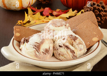 Eine Schüssel von Vanille, Schokolade und Karamell Eis mit Belgien Mandelbutter Wafer an einem Feiertag Tabelle Stockfoto