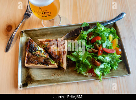 Ein Spinat und Champignons Quiche mit gemischten Salat und eine blonde Bier in der Brasserie Dieu du Ciel in Montreal, QC, Kanada Stockfoto