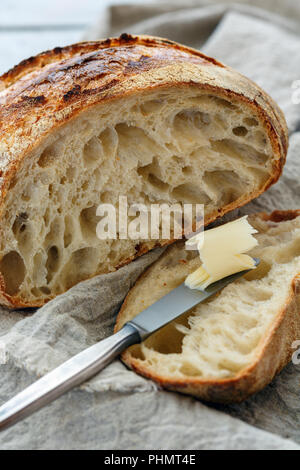 Schneiden Sie einen Laib Brot auf handwerkliche Sauerteig. Stockfoto