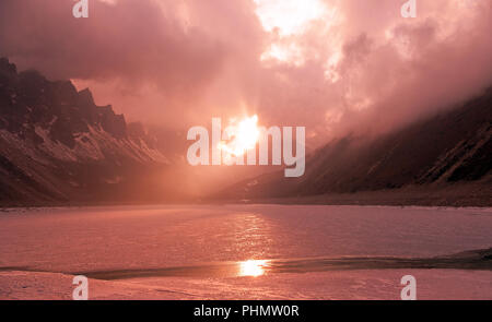 Größe der Natur Konzept: Sonnenuntergang auf einem zugefrorenen See in den Bergen. Stockfoto