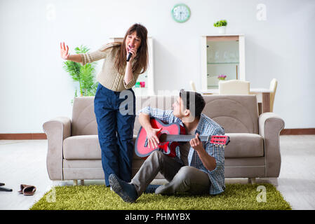 Junge Familie Singen und Spielen zu Hause Musik Stockfoto