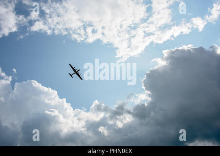 Ein Bomber aus dem zweiten Weltkrieg flying Overhead von Wolken umgeben Stockfoto