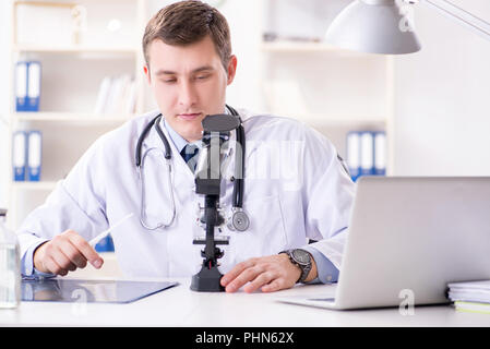 Männlicher Arzt auf Laborwerte im Krankenhaus suchen Stockfoto