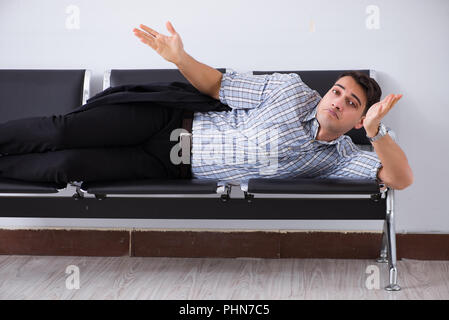 Menschen schlafen auf den Stühlen im Flughafen Stockfoto