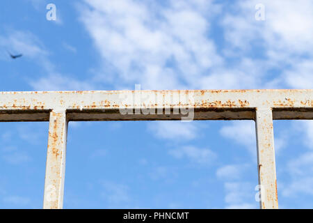 Stahl metall Zaun mit Rost gegen den blauen Himmel mit Wolken, Nahaufnahme Stockfoto