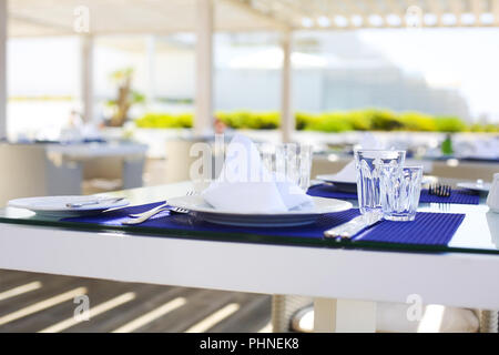 Gläser und Teller auf den Tischen Stockfoto