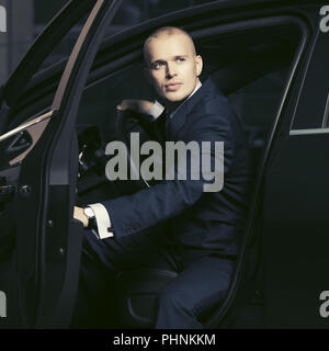 Junge gut aussehender Geschäftsmann in einem Auto sitzen Stockfoto