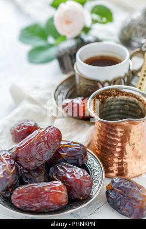 Köstliche Termine auf einer Bronzetafel und schwarzen Kaffee. Stockfoto