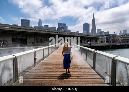 Eine Frau geht über Nebel Brücke von fujiko Nayaka, eine Kunstinstallation im Hafengebiet von San Francisco. Stockfoto