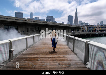 Eine Frau geht über Nebel Brücke von fujiko Nayaka, eine Kunstinstallation im Hafengebiet von San Francisco. Stockfoto