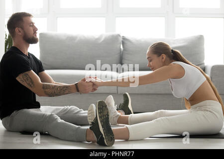 Getönten Mann helfen Freundin zurück Dehnen nach dem Training Stockfoto