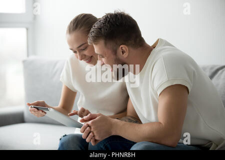 Aufgeregt Paar spielen neues Spiel auf Tablet Stockfoto