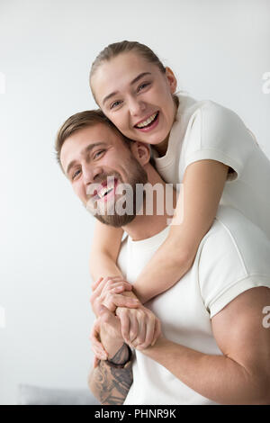 Portrait von lächelnden Freundin piggyback tätowierten Freund Stockfoto