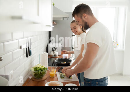 Glückliches Paar Vorbereitung Frühstück zusammen in der Küche am Morgen Stockfoto