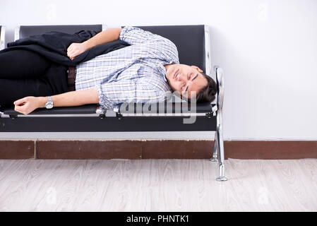 Menschen schlafen auf den Stühlen im Flughafen Stockfoto