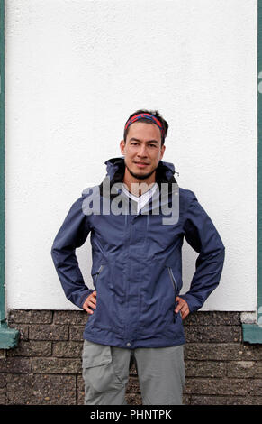 Mann in Wandern Outfit vor der weißen Wand Stockfoto