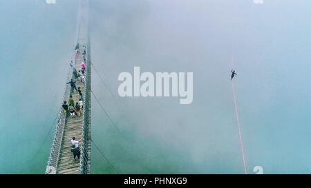 Peking, der chinesischen Provinz Zhejiang. 25 Aug, 2018. Die Menschen sehen ein Mann zu Fuß auf einem gurtband beim Slacklining Wettbewerb im malerischen Ort Shenxianju Xianju County, in der ostchinesischen Provinz Zhejiang, Aug 25., 2018. Credit: Zhu Cheng/Xinhua/Alamy leben Nachrichten Stockfoto
